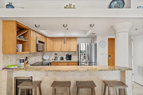 a kitchen with stainless steel appliances granite countertop a sink and a refrigerator