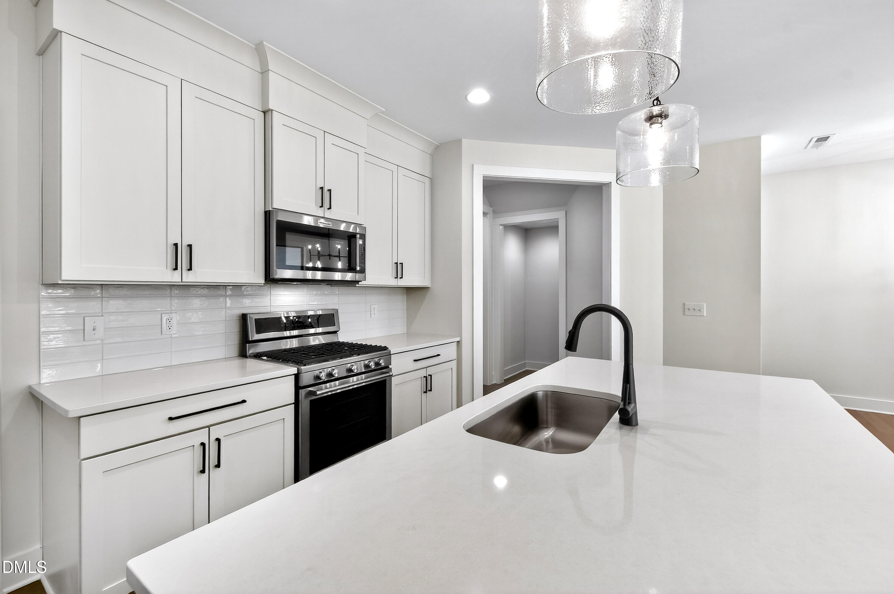 976 Double Helix Road Apex, NC 27523 - Photo 11 of 50 a kitchen with a white stove top oven and white cabinets