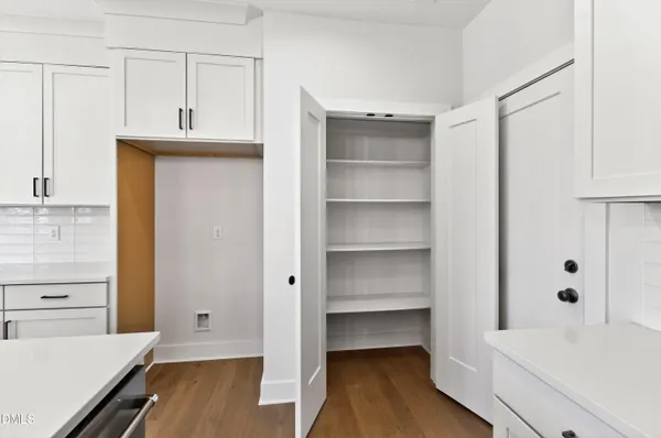 a view of a kitchen with wooden floor and cabinets