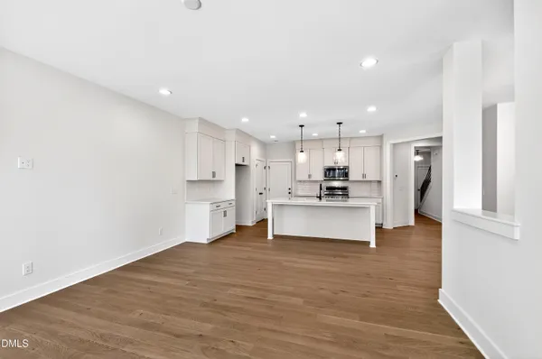 a view of kitchen with kitchen island white cabinets and stainless steel appliances