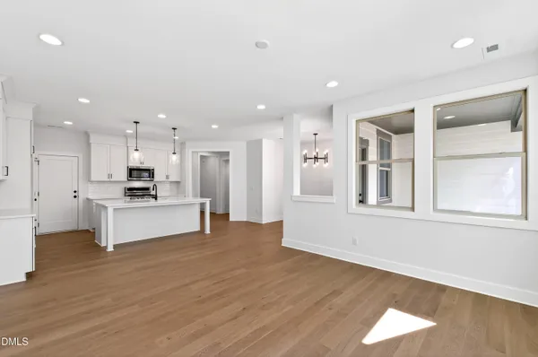 a view of kitchen with kitchen island white cabinets and wooden floor