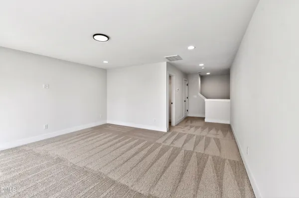 a view of a big room with wooden floor and windows