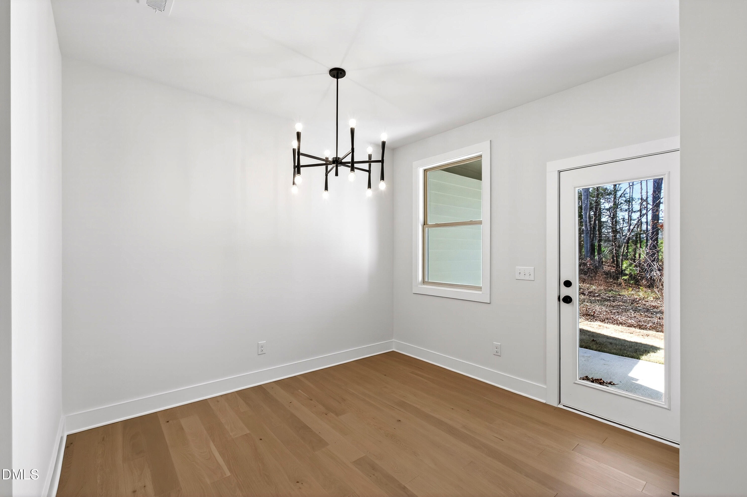 976 Double Helix Road Apex, NC 27523 - Photo 4 of 50 a view of empty room with wooden floor and fan