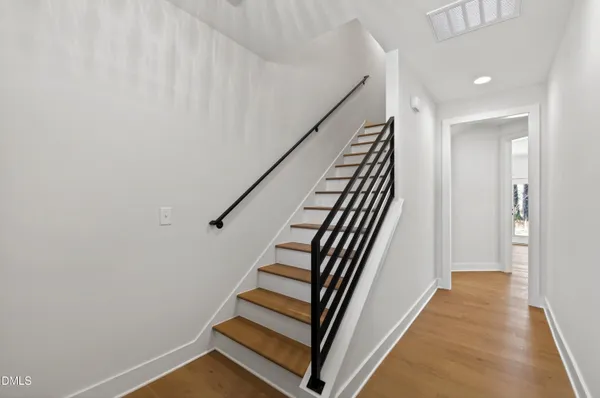 a view of a hallway with wooden floor and stairs