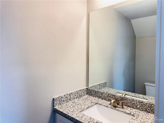 a bathroom with a granite countertop sink and vanity