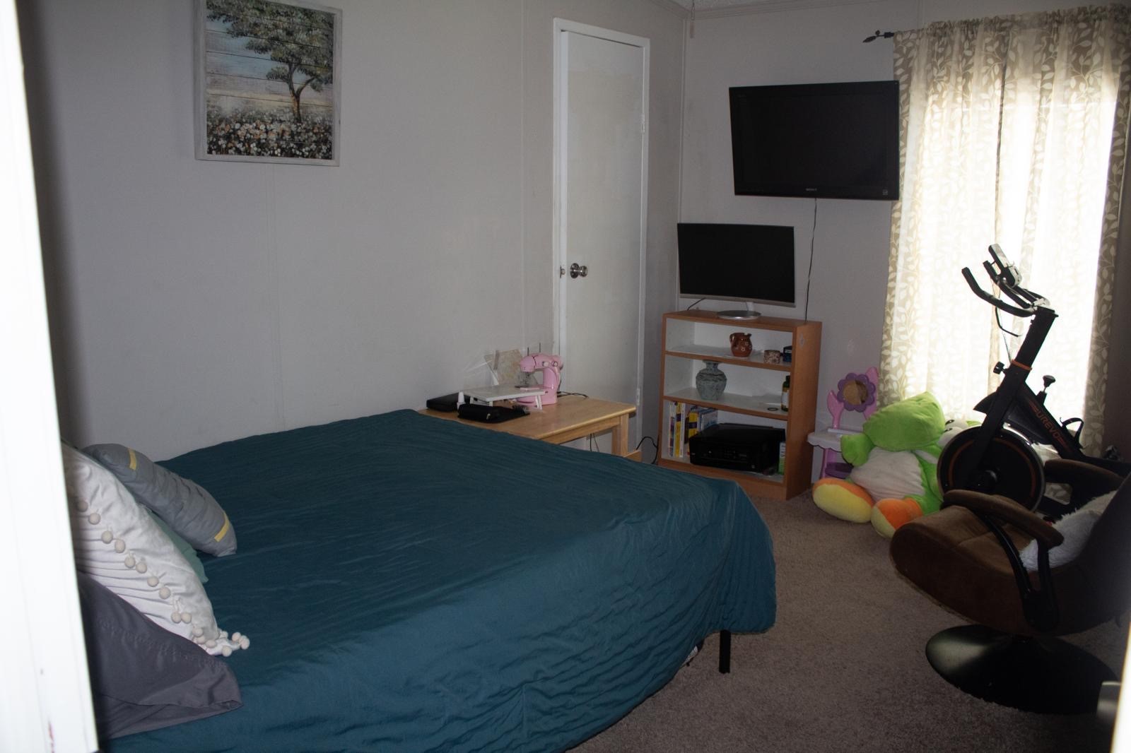 8021 Matthew Steven Drive Conroe, TX 77306 - Photo 18 of 24 a bedroom with a bed and a flat tv screen on the dresser