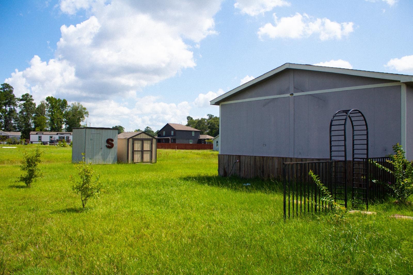 8021 Matthew Steven Drive Conroe, TX 77306 - Photo 19 of 24 a backyard of a house with lots of green space
