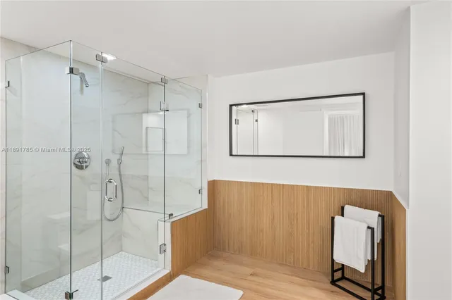 a bathroom with a shower a mirror and a sink