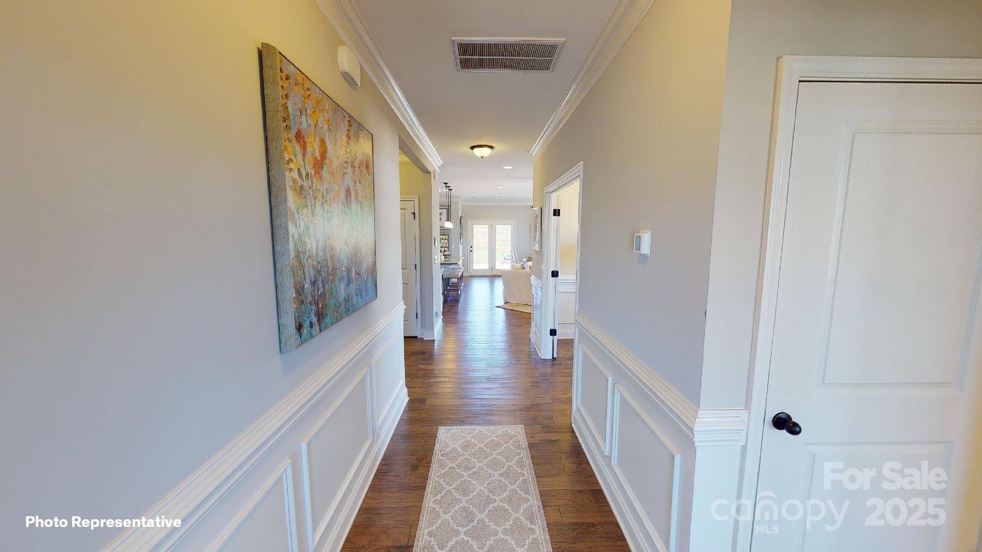 112 Noah Lane Troutman, NC 28166 - Photo 16 of 27 a view of a hallway with wooden floor and staircase