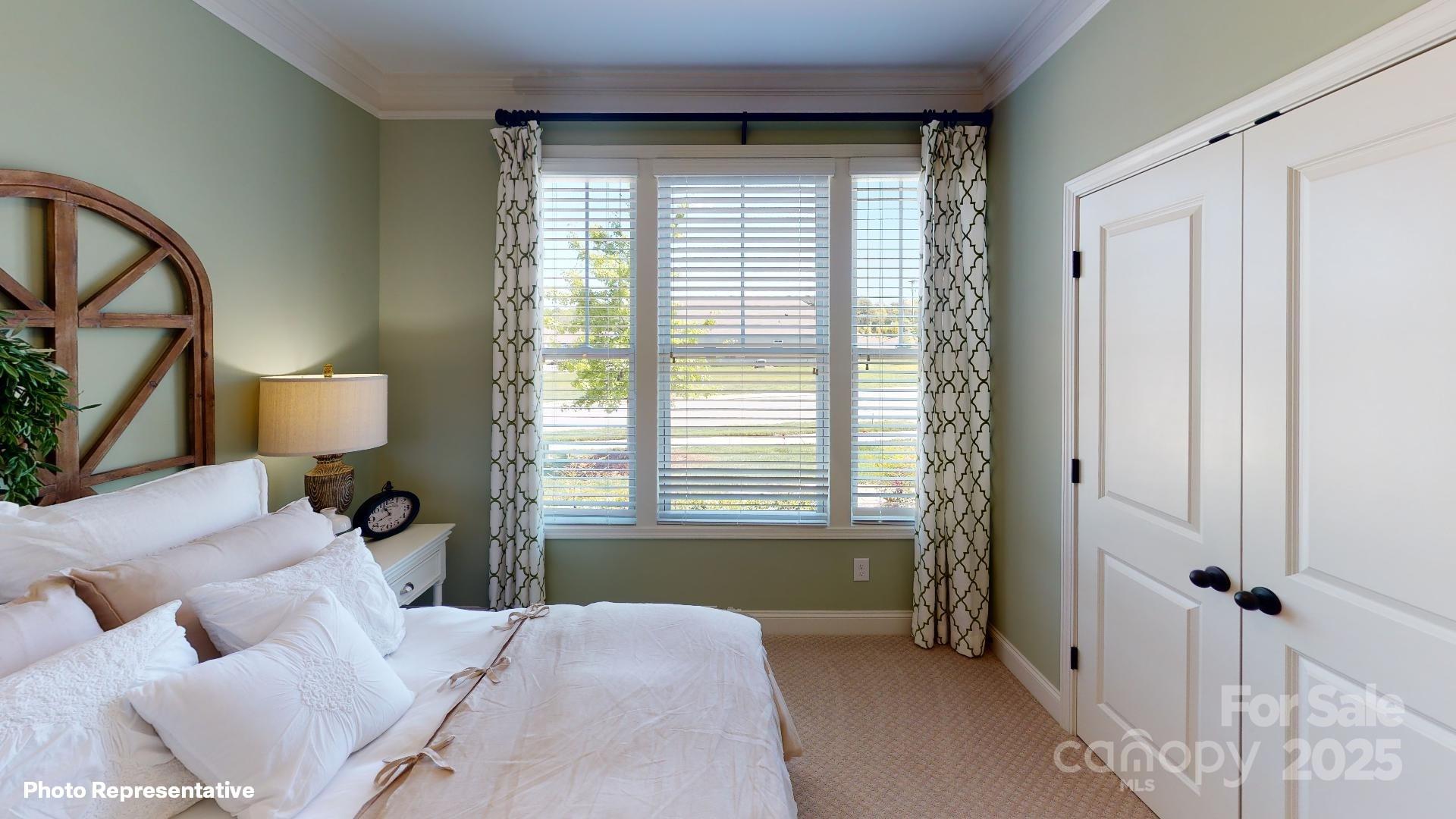 112 Noah Lane Troutman, NC 28166 - Photo 23 of 27 a bedroom with a bed a mirror and a window