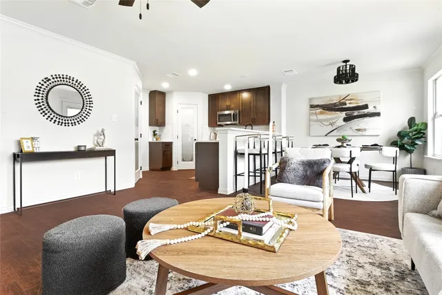 a living room with furniture a flat screen tv and kitchen view