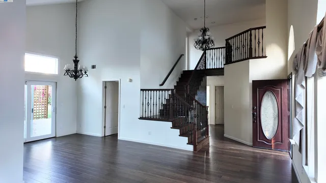 a view of hallway with stairs and wooden floor