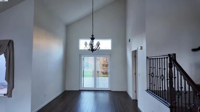 a view of a hallway with wooden floor and chandelier