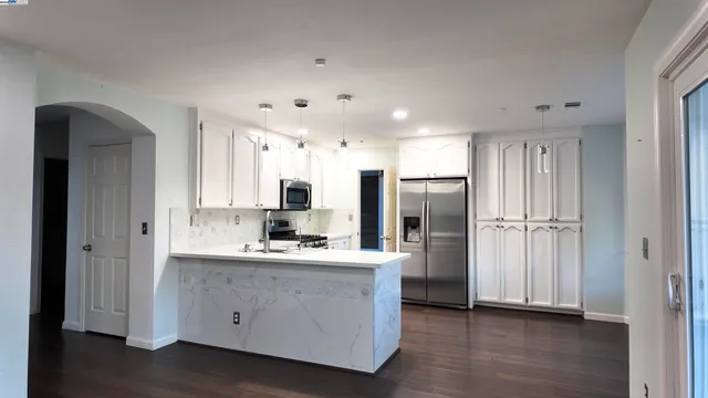 a kitchen with stainless steel appliances a refrigerator sink and cabinets