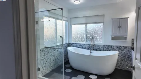 a white bath tub sitting in a bathroom next to a window