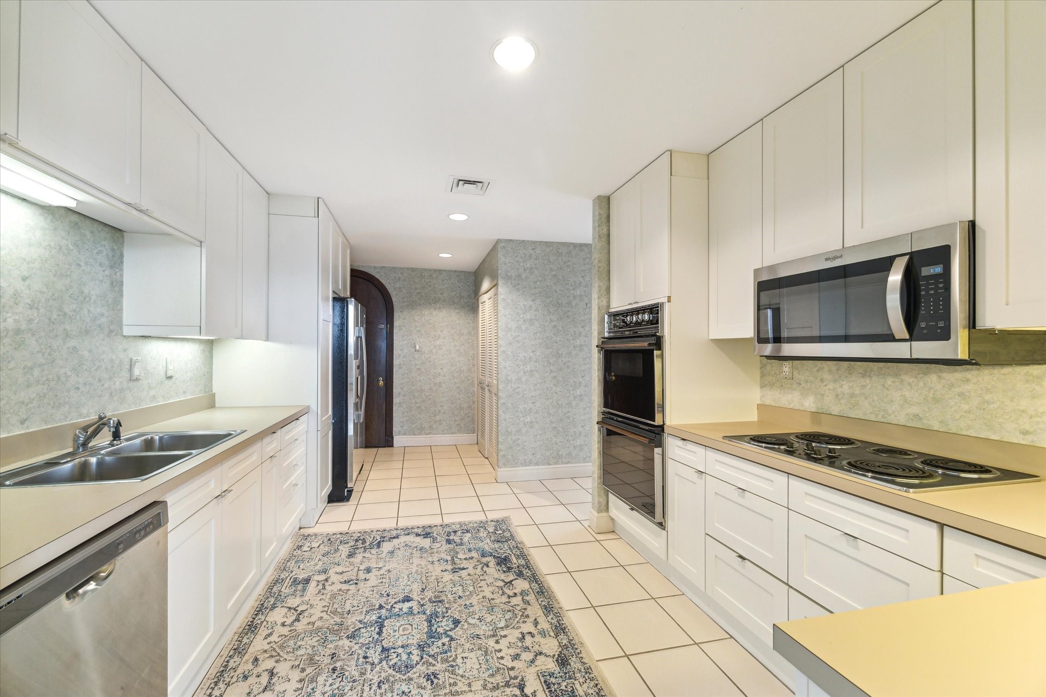1111 Hermann Drive, Unit 7F Houston, TX 77004 - Photo 11 of 42 a kitchen with stainless steel appliances kitchen island granite countertop a sink and cabinets