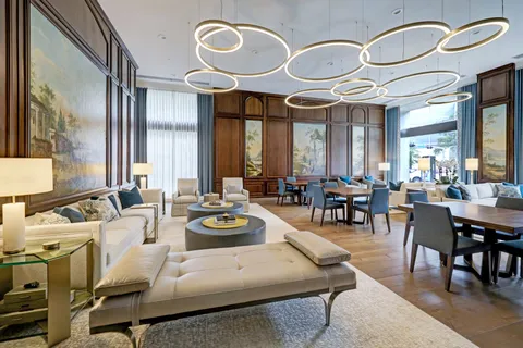 a living room with couches a dining table and chairs with wooden floor