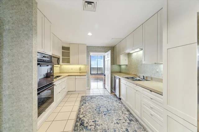 a kitchen with stainless steel appliances kitchen island granite countertop a sink and cabinets