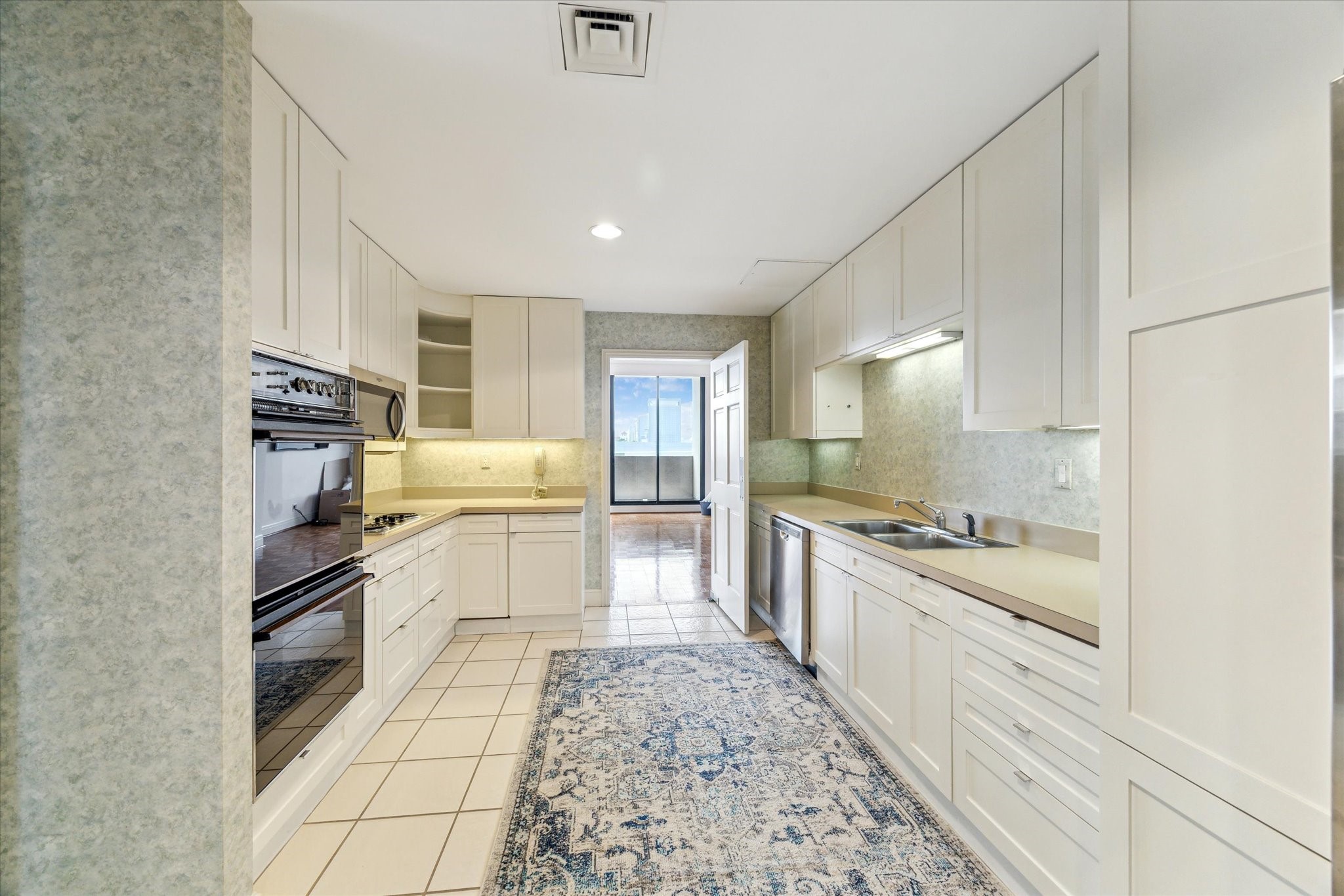 1111 Hermann Drive, Unit 7F Houston, TX 77004 - Photo 10 of 42 a kitchen with granite countertop a stove top oven sink and cabinets