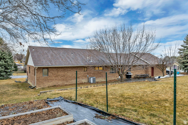 887 Village Way Alpine, UT 84004 - Photo 7 of 28 View of side of property featuring brick siding, a shingled roof, a yard, a patio, and a vegetable garden