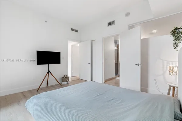 a bedroom with a bed and a flat screen tv