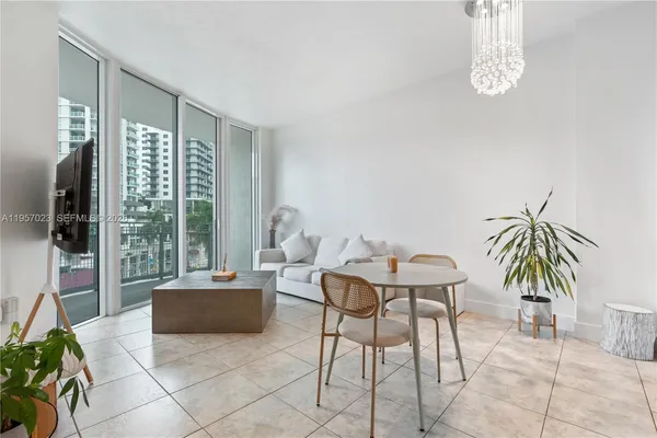 a living room with furniture and a floor to ceiling window