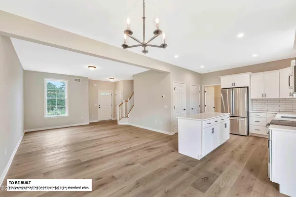 a large white kitchen with wooden floors and white walls