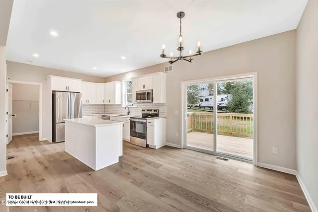 a open kitchen with white cabinets and refrigerator