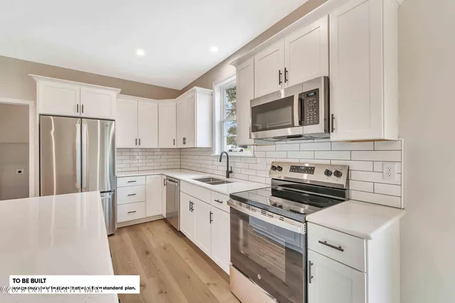 a kitchen with stainless steel appliances granite countertop a stove a sink and a microwave