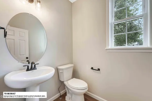 a bathroom with a toilet a sink and a mirror