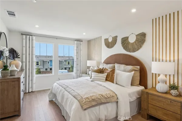 a bedroom with a bed and dresser with mirror