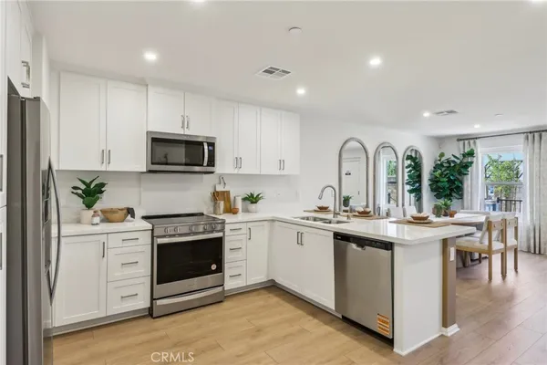 a kitchen with white cabinets and appliances