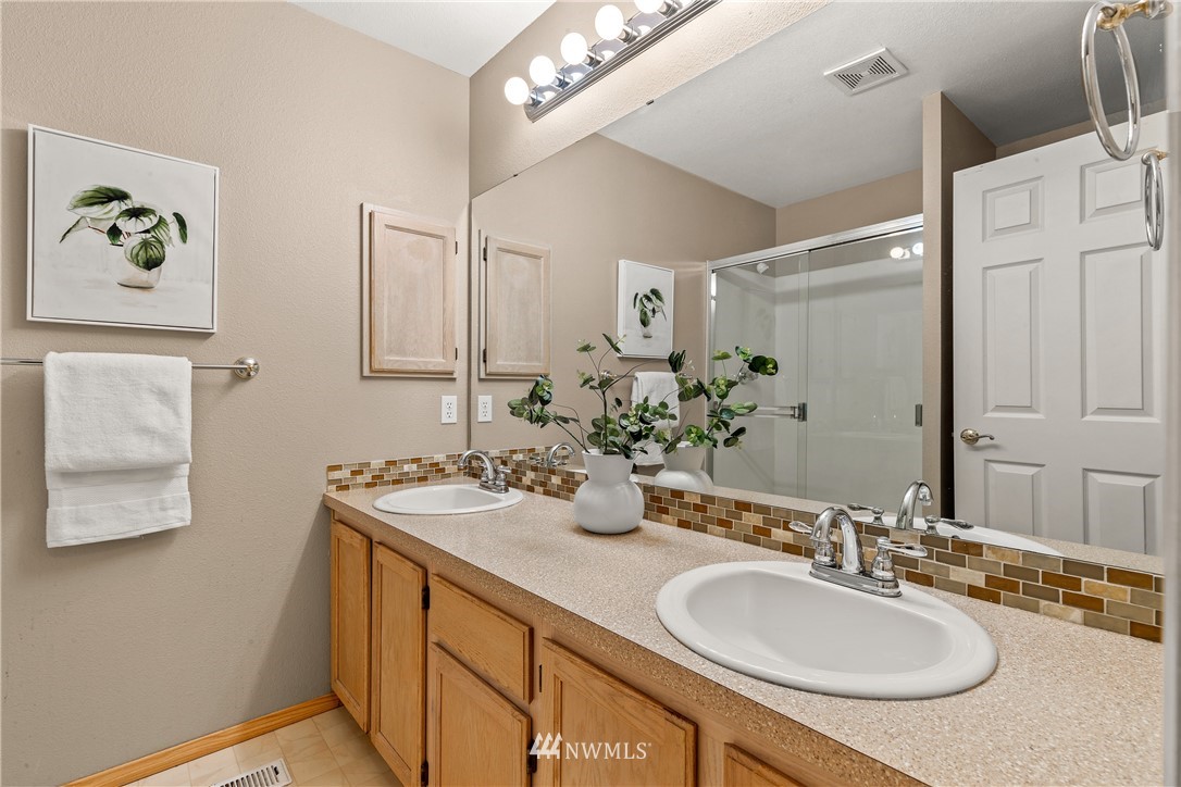18704 20th Avenue Southeast Bothell, WA 98012 - Photo 19 of 27 a bathroom with a granite countertop sink a mirror and a shower