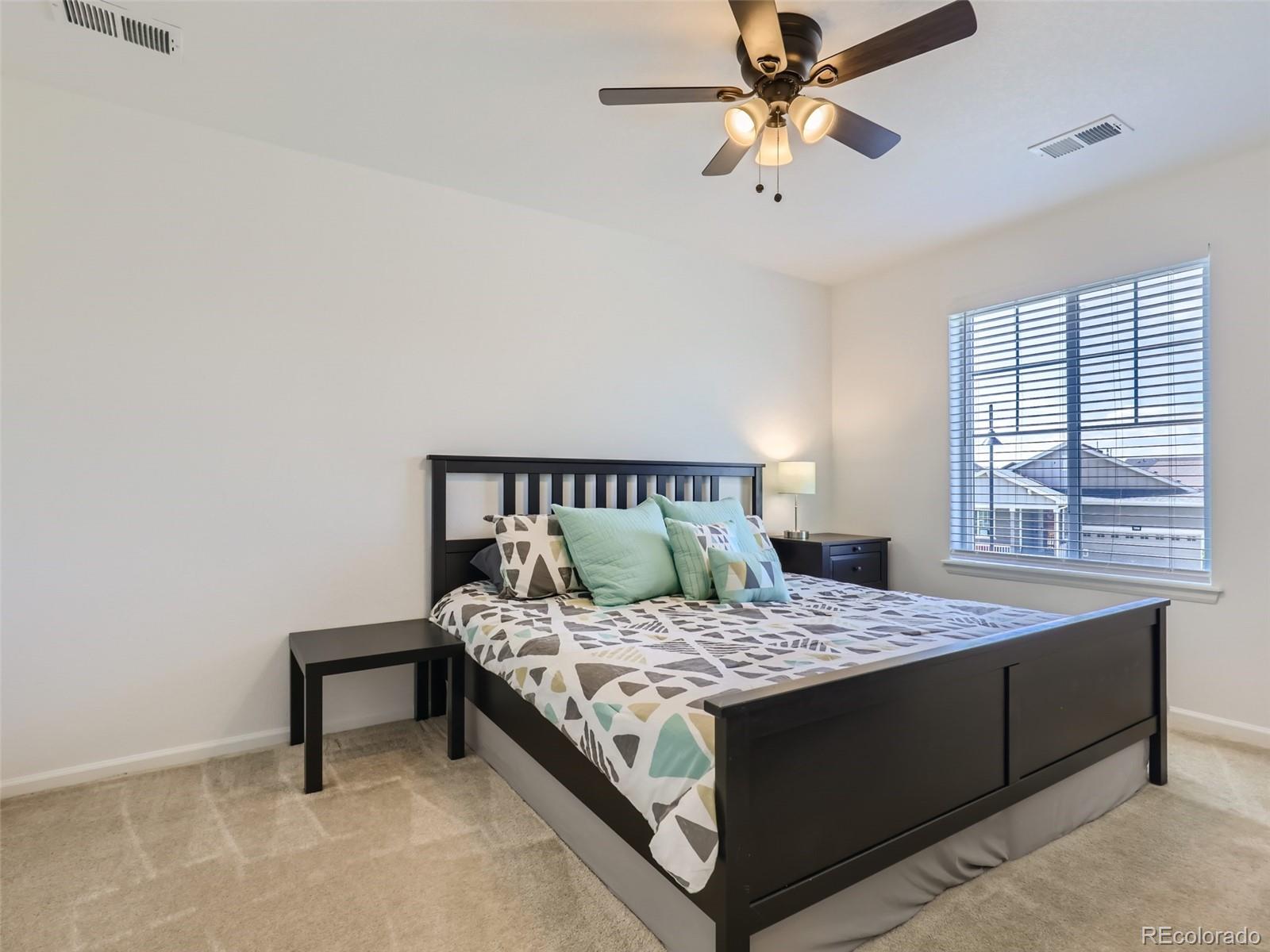 6430 Dry Fork Circle Frederick, CO 80516 - Photo 20 of 32 a bedroom with a bed and a chandelier
