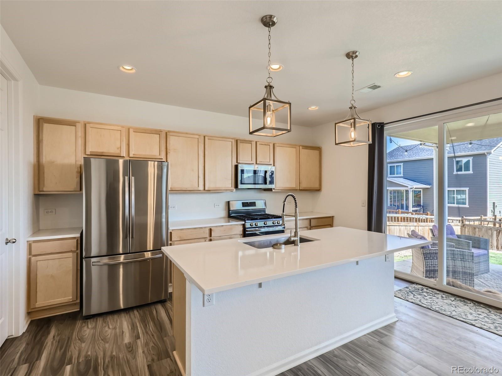 6430 Dry Fork Circle Frederick, CO 80516 - Photo 5 of 32 a kitchen with stainless steel appliances granite countertop a refrigerator a sink a stove and a wooden floors