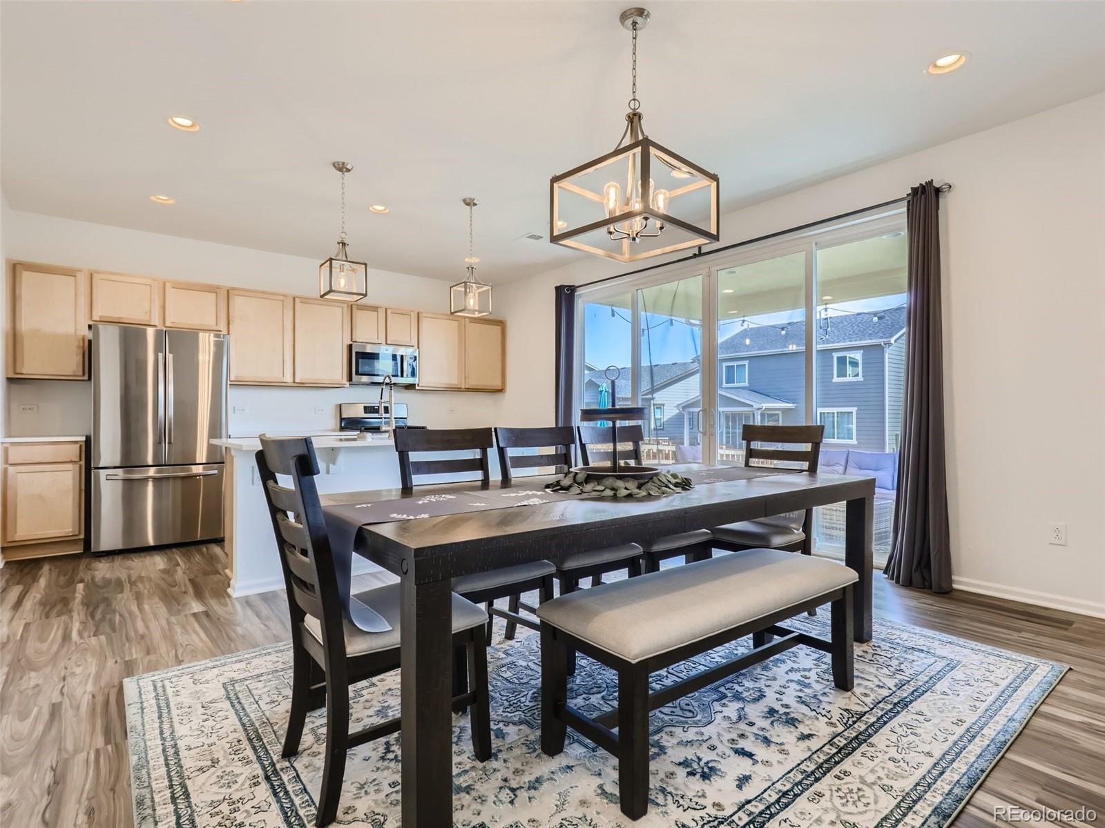 6430 Dry Fork Circle Frederick, CO 80516 - Photo 7 of 32 a kitchen with stainless steel appliances a dining table chairs stove refrigerator and cabinets