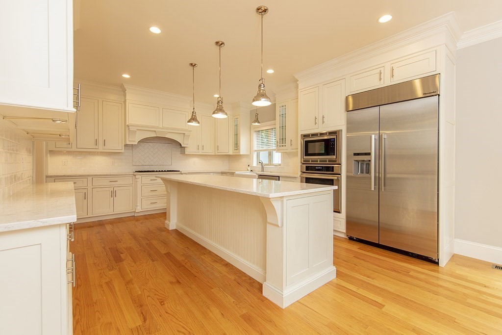 33 Liberty Avenue Lexington, MA 02420 - Photo 4 of 30 a kitchen with kitchen island white cabinets and stainless steel appliances