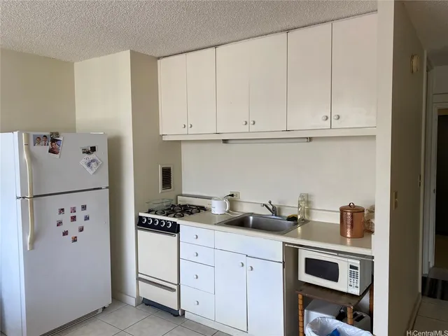a kitchen with white cabinets and white appliances
