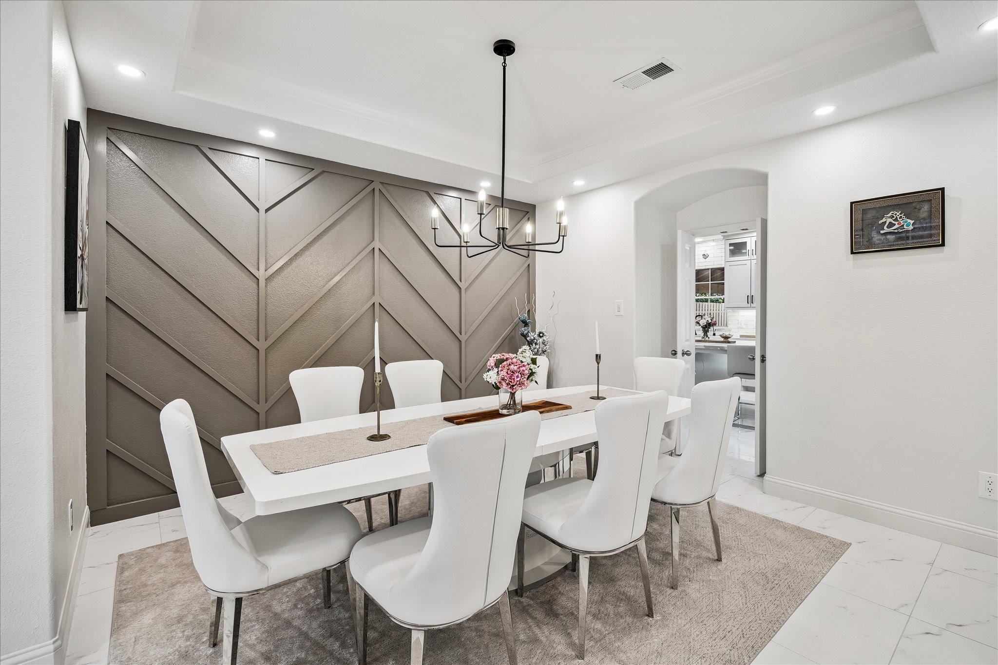 15 West Beckonvale Circle The Woodlands, TX 77382 - Photo 9 of 44 The spacious dining room features designer lighting, a gorgeous slate gray accent wall, and a tray ceiling. This area offers seamless access to the kitchen and other living spaces.