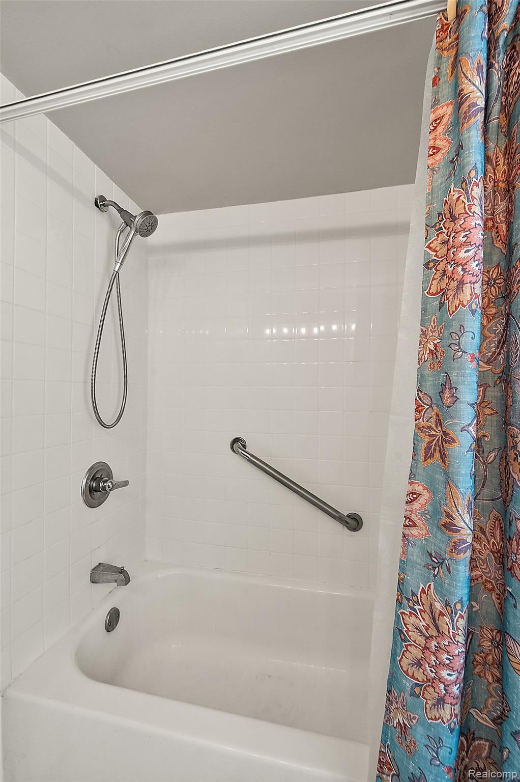 930 Little Hill Court Rochester, MI 48307 - Photo 35 of 38 Bathtub and shower combination featuring white subway tile surround, polished chrome fixtures, and a grab bar