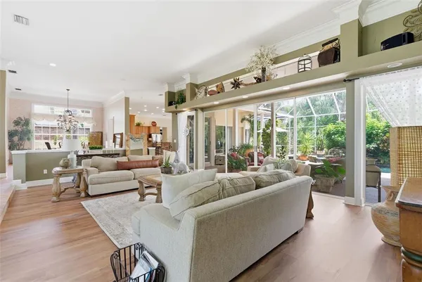 a living room with furniture a flat screen tv and a large window
