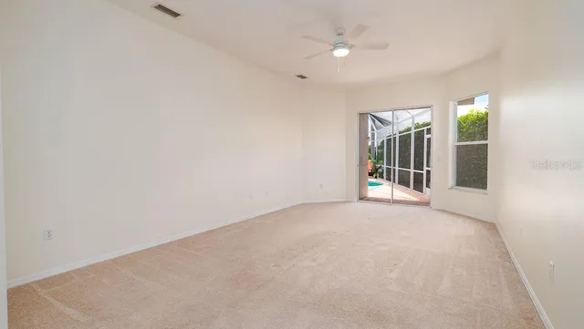 an empty room with a window and a ceiling fan