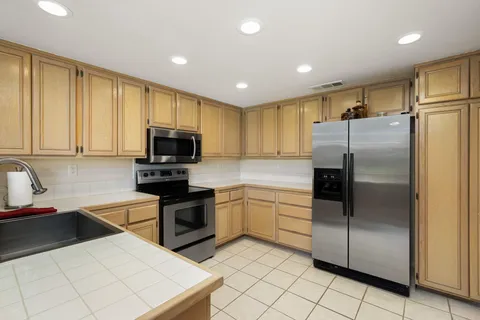 a bedroom with a bed and a flat tv screen on dresser
