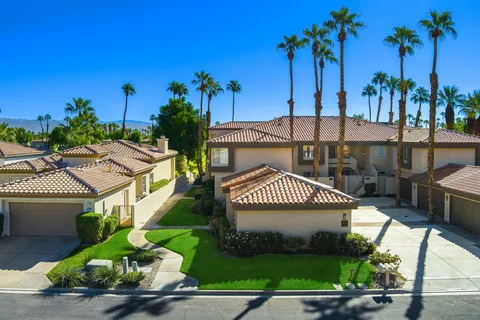 a view of a chairs and table in patio with a yard