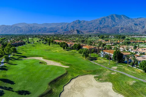 a living room with furniture a ceiling fan and a large window