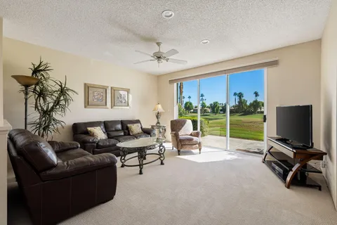 a kitchen with stainless steel appliances granite countertop a stove top oven a sink dishwasher a dining table and chairs with wooden floor