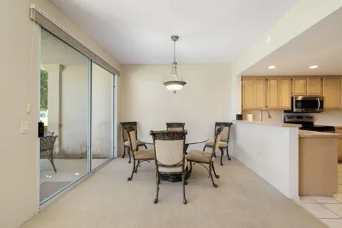 a kitchen with kitchen island a large window cabinets and stainless steel appliances