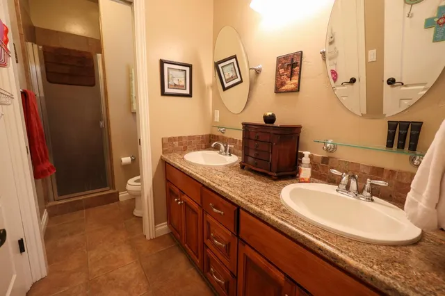 a bathroom with a granite countertop sink a mirror and a shower