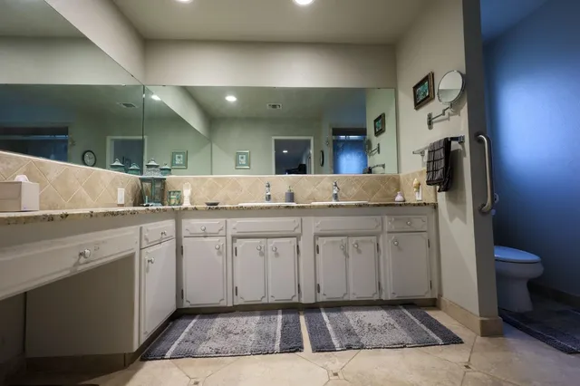 a spacious bathroom with a granite countertop sink and a mirror