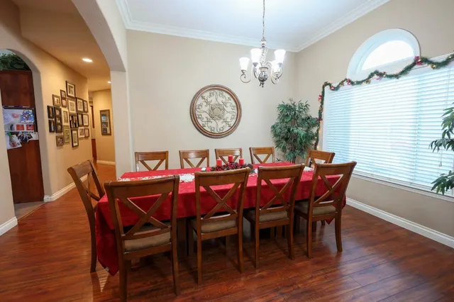 a view of a dining room with furniture wooden floor and a chandelier